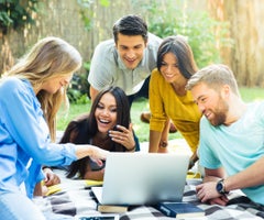 Happy student using laptop in campus