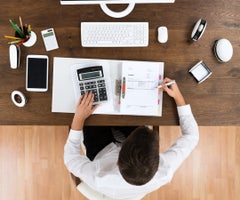 High Angle View Of Young Male Accountant Checking Invoice In Office