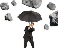 Businessman shelters from the storm of crisis