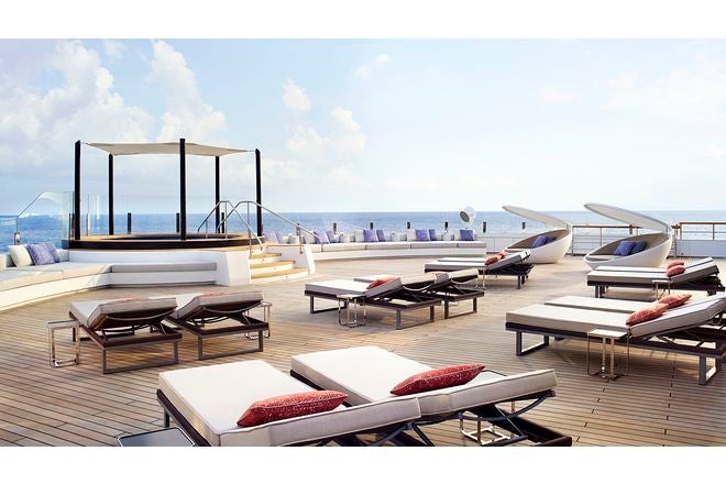 Zona de hamacas y jacuzzi en la cubierta, con suelo de madera de teca y vistas al horizonte.