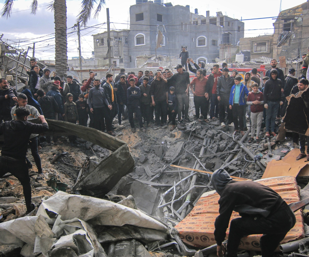 Los palestinos buscan entre los escombros de los edificios destruidos por un ataque aéreo israelí en Khan Younis, en el sur de Gaza, el viernes 12 de enero de 2024.