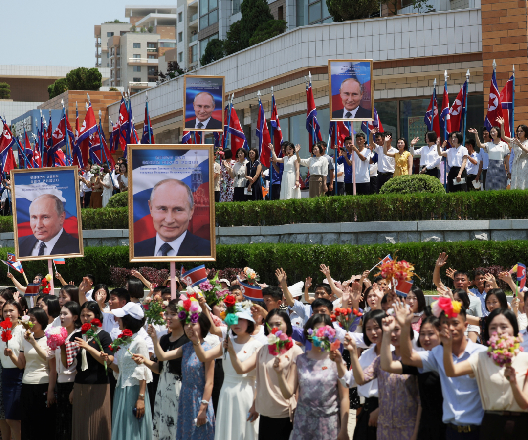 Un grupo de personas saluda a la comitiva del Presidente ruso Vladimir Putin en Pyongyang, Corea del Norte.