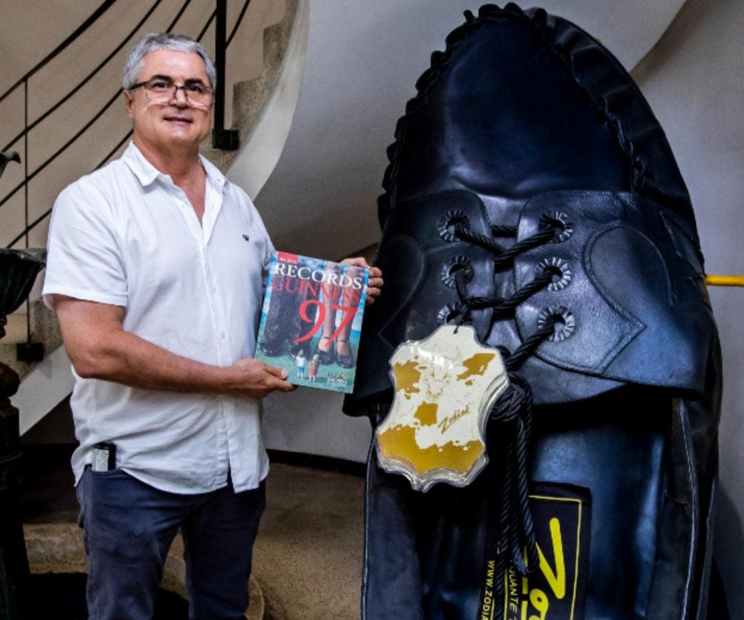 Andrés Posada, gerente y fundador de Zodiak, posa junto al zapato gigante que le valió ingresar a los Guiness Record