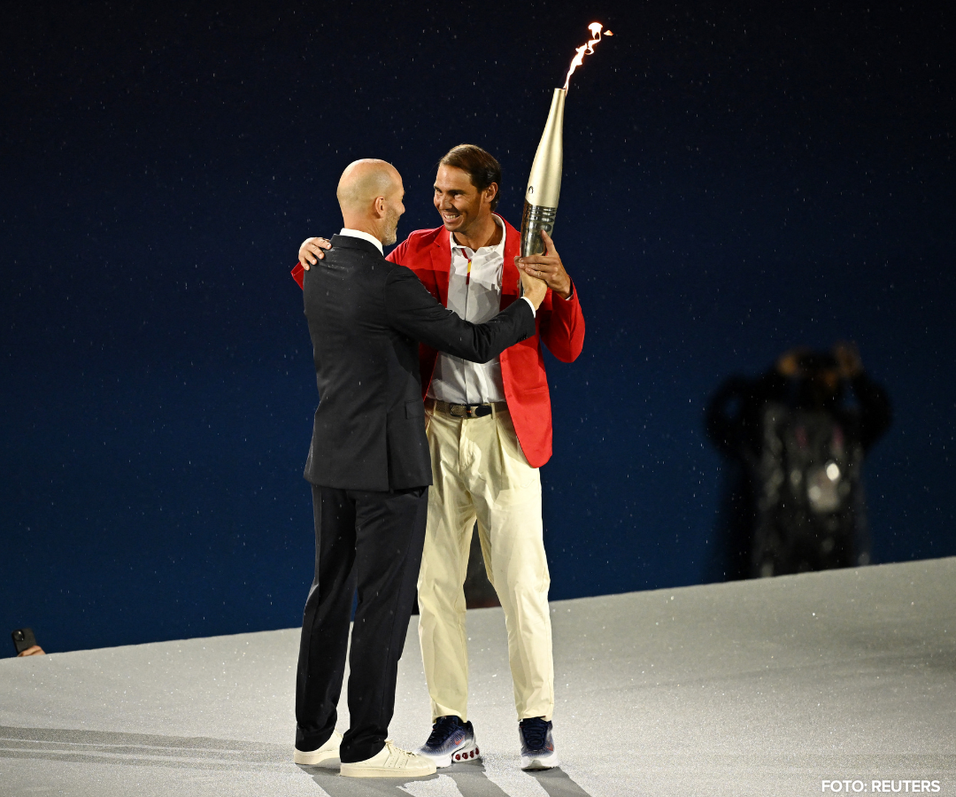 El ex futbolista Zinedine Zidane pasa la antorcha olímpica al tenista Rafael Nadal durante la ceremonia inaugural