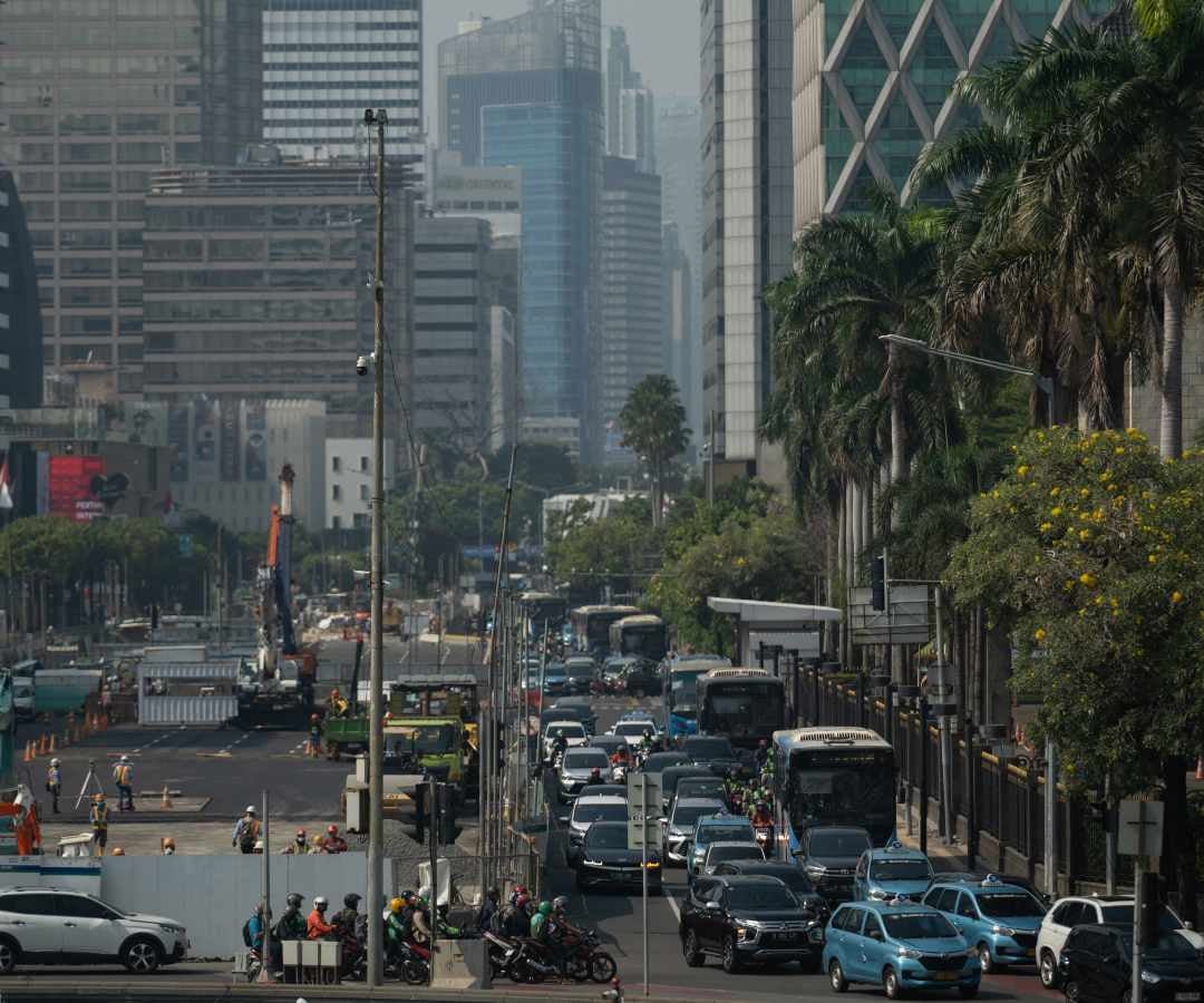 Vehículos en circulación junto a las obras de construcción de un tren de tránsito rápido masivo en Yakarta, Indonesia