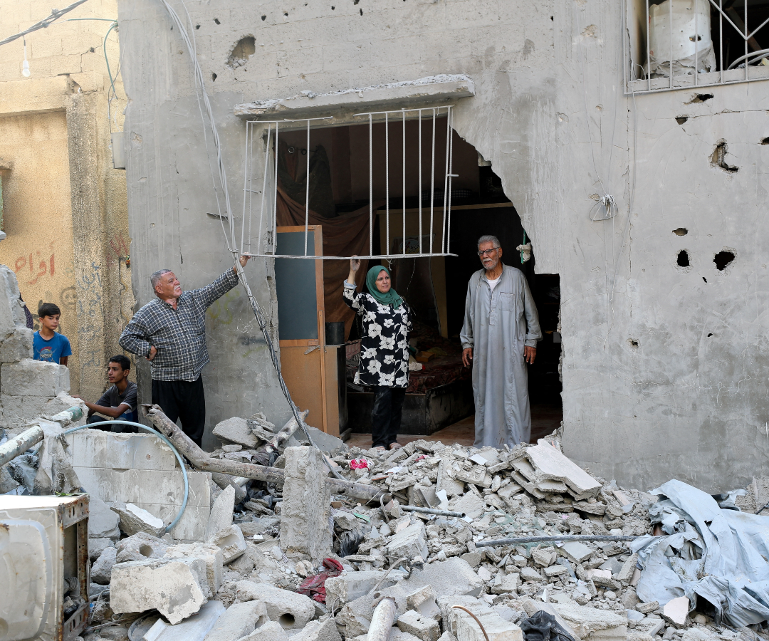 Palestinos inspeccionan el lugar de un ataque aéreo
