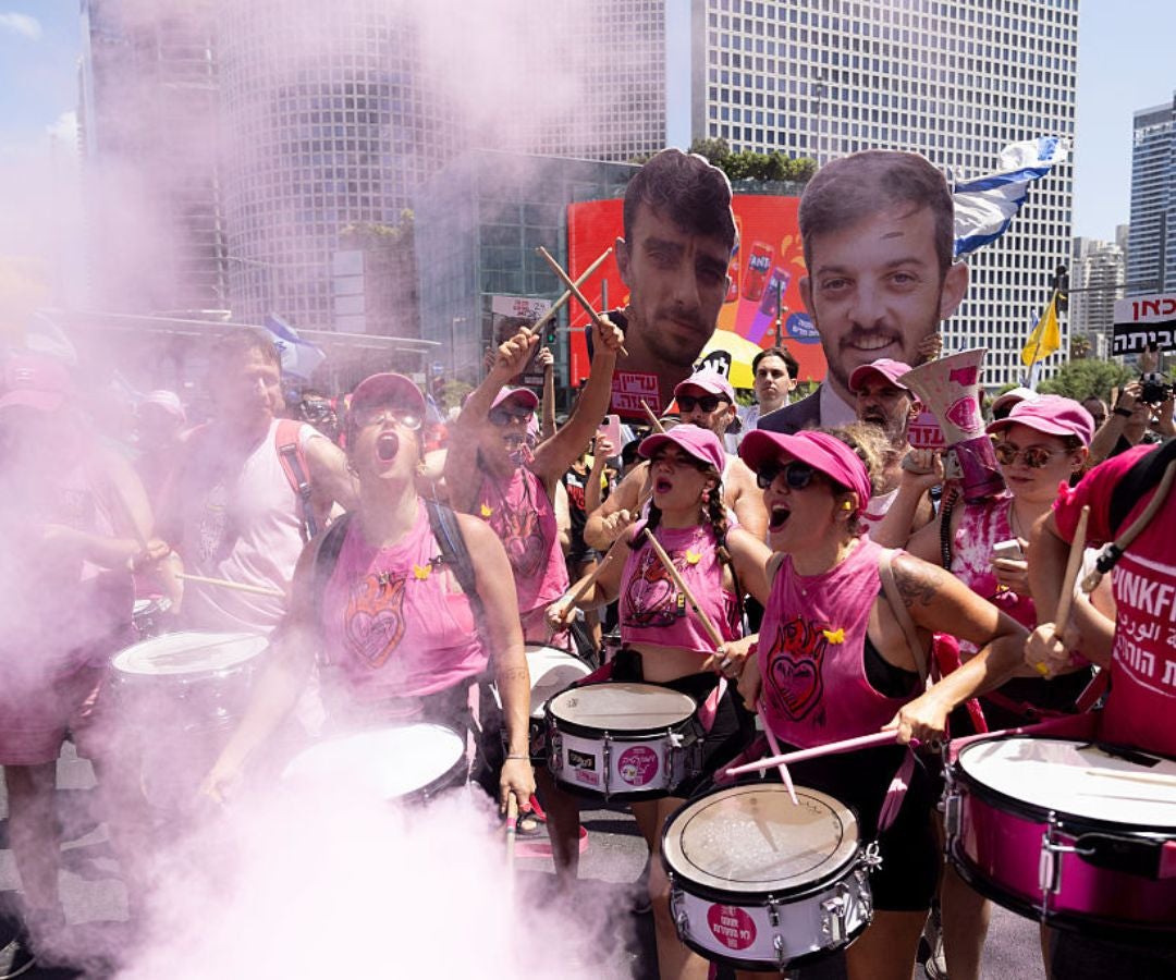 Los manifestantes gritan consignas y sostienen fotografías de rehenes durante una manifestación para pedir un acuerdo sobre los rehenes el 17 de agosto.