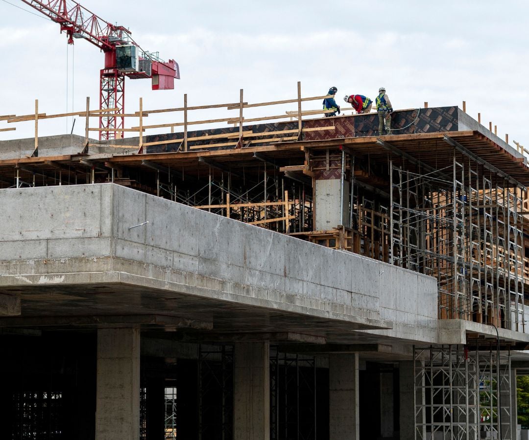 Trabajadores en una torre de viviendas de mediana altura en construcción en Victoria, Columbia Británica, Canadá.