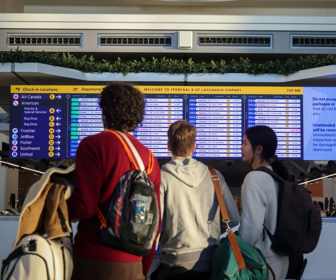 Los viajeros observan un panel de información de vuelos en la Terminal B del Aeropuerto LaGuardia (LGA) en el distrito de Queens de Nueva York