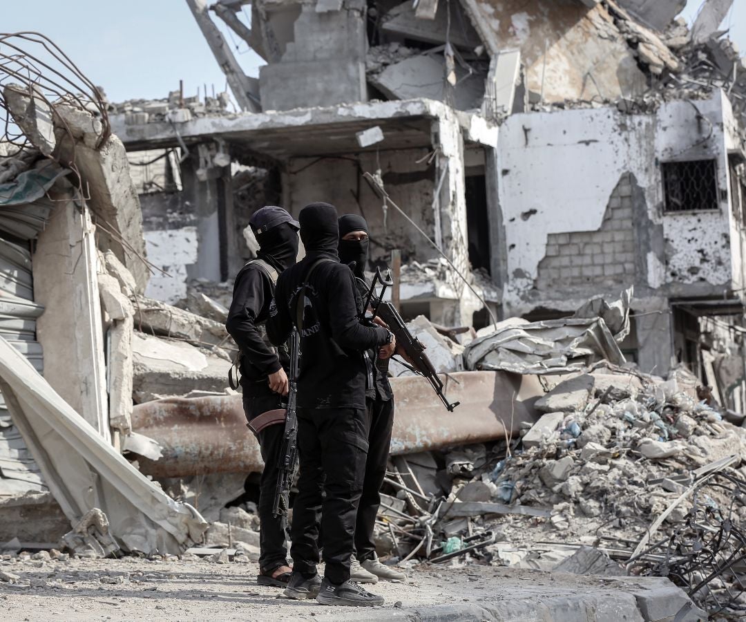 Militantes de las Brigadas Al-Qassam, el brazo armado de Hamás, montan guardia mientras miembros de la Cruz Roja supervisan una operación de búsqueda de los cadáveres de rehenes israelíes en el este de Gaza