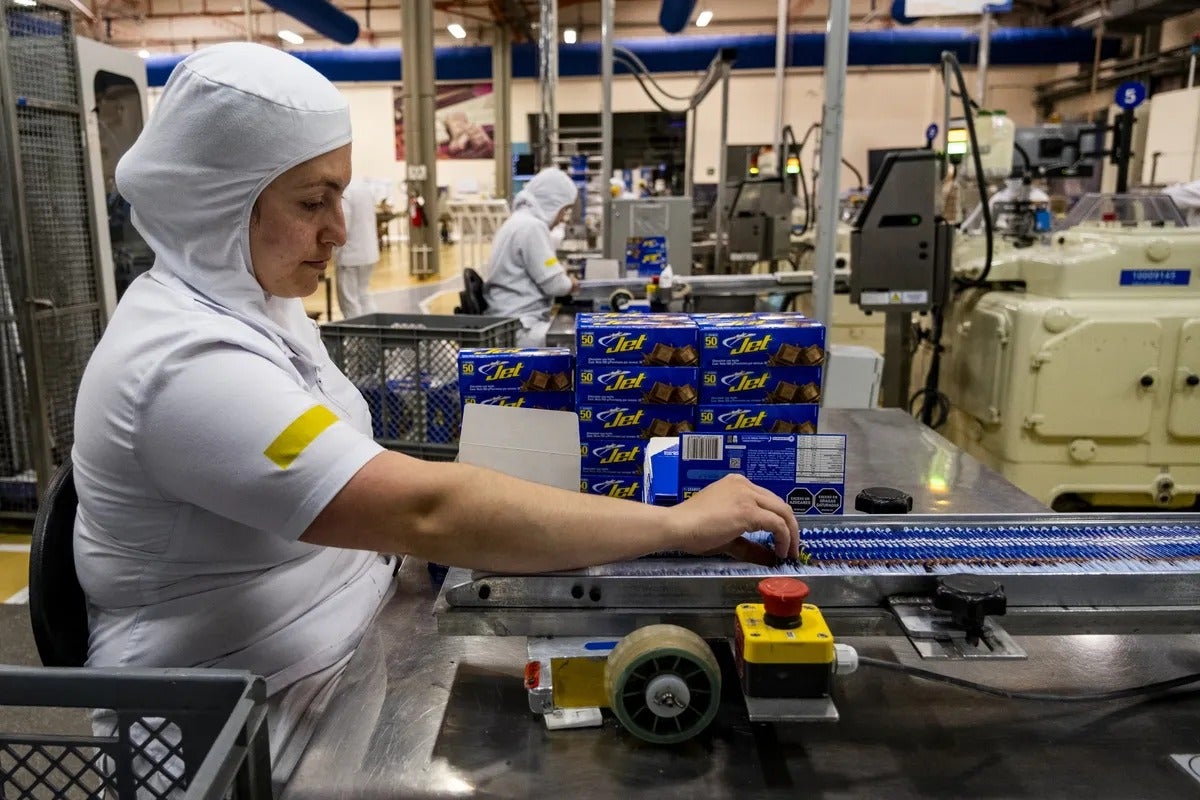 Un trabajador empaca las icónicas barras de chocolate con leche Chocolatina Jet