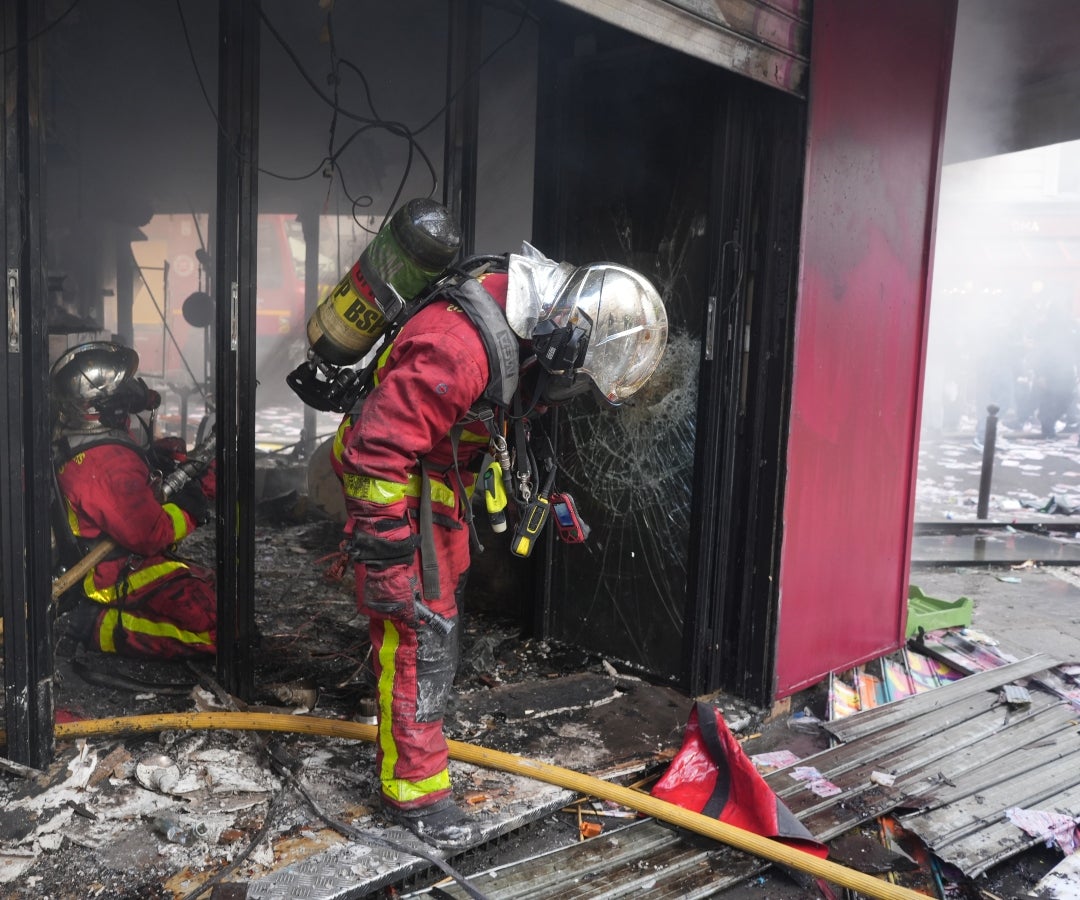 Bomberos evalúan los daños materiales durante unas manifestaciones en París, Francia
