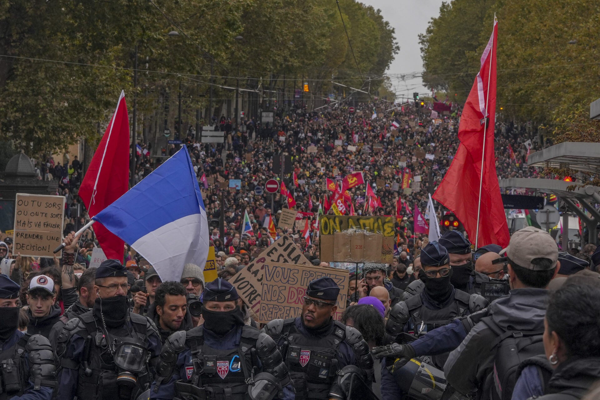 Agentes antidisturbios de la CRS, unidad de la Policía Nacional francesa, vigilan cerca de los manifestantes durante una protesta en París el 24 de octubre.